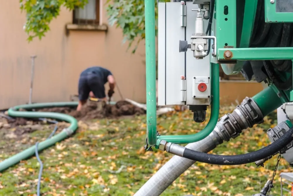 a person checking the septic system and a septic pumper truck